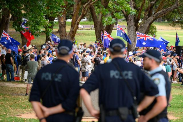 Police officers keep watch during the anti-immigration 'Put Australia First' rally at Prince Alfred Park in Sydney on December 21, 2025, one week after the Bondi Beach mass shooting. (Photo by GEORGE CHAN / AFP)