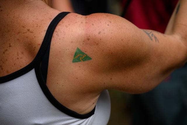 An 'Australian Made' tattoo is seen on the shoulder of a participant during the anti-immigration 'Put Australia First' rally at Prince Alfred Park in Sydney on December 21, 2025, one week after the Bondi Beach mass shooting. (Photo by GEORGE CHAN / AFP)