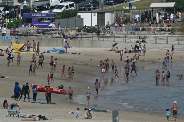 People are seen at Bondi Beach ahead of a memorial for the victims of a shooting in Sydney on December 21, 2025. (Photo by Saeed KHAN / AFP)