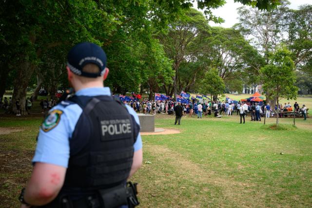 A police officer keeps watch during the anti-immigration 'Put Australia First' rally at Prince Alfred Park in Sydney on December 21, 2025, one week after the Bondi Beach mass shooting. (Photo by GEORGE CHAN / AFP)