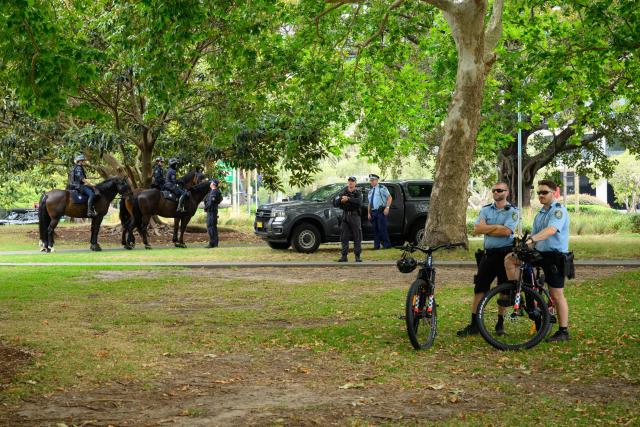 Police officers keep watch during the anti-immigration 'Put Australia First' rally at Prince Alfred Park in Sydney on December 21, 2025, one week after the Bondi Beach mass shooting. (Photo by GEORGE CHAN / AFP)