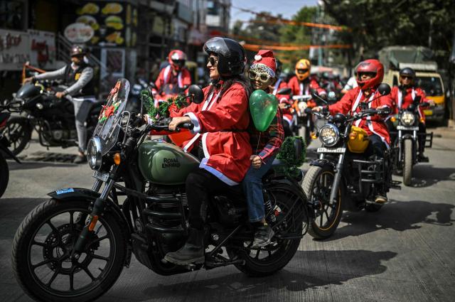 Motorcyclists dressed as Santa Claus take part in a Christmas-themed rally in support of specially abled children, marking the start of Christmas festivities in Bengaluru on December 21, 2025. (Photo by Idrees MOHAMMED / AFP)