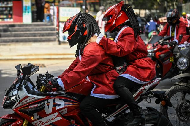 Motorcyclists dressed as Santa Claus take part in a Christmas-themed rally in support of specially abled children, marking the start of Christmas festivities in Bengaluru on December 21, 2025. (Photo by Idrees MOHAMMED / AFP)