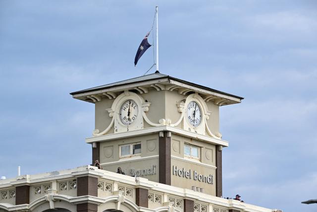 Police snipers are seen on a roof as they secure the area during the memorial held for the victims of a shooting at Bondi Beach in Sydney on December 21, 2025. A father and his son are accused of spraying bullets into the family-thronged Hanukkah celebration at Sydney's most famous beach on December 14, allegedly inspired by "Islamic State ideology". (Photo by Saeed KHAN / AFP)