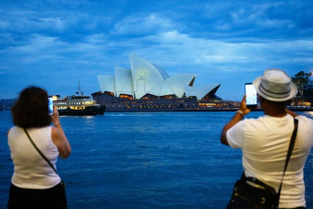 The Sydney Opera House is illuminated with candlelights in Sydney on December 21, 2025, as part of a national day of reflection honouring the victims of the Bondi Beach terrorist attack. Australians fell silent in flickering candlelight to honour the Bondi Beach shooting victims, marking one week since gunmen fired into crowds at a Jewish festival. (Photo by GEORGE CHAN / AFP)