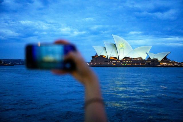 The Sydney Opera House is illuminated with candlelights in Sydney on December 21, 2025, as part of a national day of reflection honouring the victims of the Bondi Beach terrorist attack. Australians fell silent in flickering candlelight to honour the Bondi Beach shooting victims, marking one week since gunmen fired into crowds at a Jewish festival. (Photo by GEORGE CHAN / AFP)