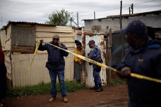 South African Police Service (SAPS) officers put up crime scene tape at the scene of an attack at a tavern in Bekkersdal on December 21, 2025. Nine people were killed when gunmen opened fire at a bar outside Johannesburg early on December 21, 2025.
Ten more were wounded in the early morning attack at the tavern at Bekkersdal, in a gold mining area around 40 kilometres (25 miles) southwest of the city. (Photo by EMMANUEL CROSET / AFP)