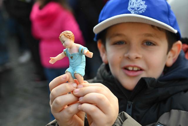 A child holds a Nativity Scene figurine of baby Jesus before the traditional blessing of figurines as part of the pope's Sunday Angelus prayer before Christmas in Saint Peter's Square in the Vatican on December 21, 2025. (Photo by Andreas SOLARO / AFP)