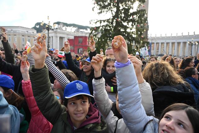 Children hold a Nativity Scene figurine of baby Jesus before the traditional blessing of figurines as part of the pope's Sunday Angelus prayer before Christmas in Saint Peter's Square in the Vatican on December 21, 2025. (Photo by Andreas SOLARO / AFP)