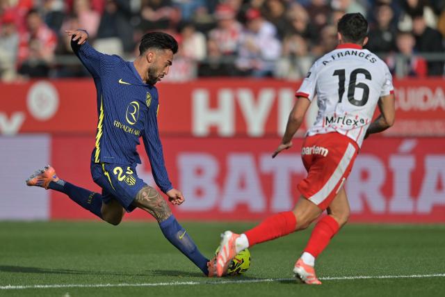 Atletico Madrid's Argentine midfielder #23 Nico Gonzalez (L) and Girona's Spanish defender #16 Alejandro Frances fight for the ball during the Spanish league football match between Girona FC and Club Atletico de Madrid at Montilivi Stadium in Girona on December 21, 2025. (Photo by MANAURE QUINTERO / AFP)