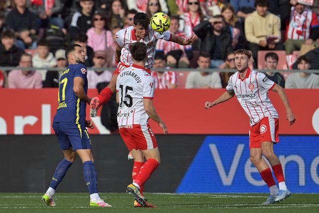 Girona's Spanish defender #16 Alejandro Frances heads the ball during the Spanish league football match between Girona FC and Club Atletico de Madrid at Montilivi Stadium in Girona on December 21, 2025. (Photo by MANAURE QUINTERO / AFP)