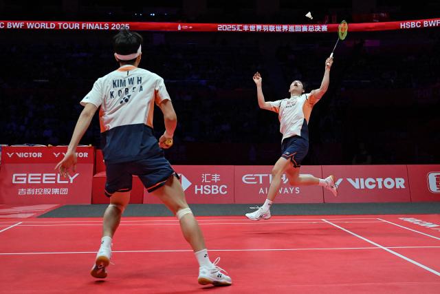 South Korea’s Seo Seung-jae (R) and Kim Won-ho play a point against China’s Liang Weikeng and Wang Chang during their men’s doubles final match at the BWF Badminton World Tour Finals in the Hangzhou Olympic Sports Centre Gymnasium of Hangzhou, in eastern China's Zhejiang province on December 21, 2025. (Photo by Jade Gao / AFP)