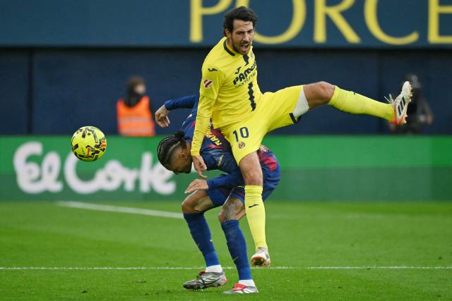 Barcelona's Brazilian forward #11 Raphinha (L) and Villarreal's Spanish midfielder #10 Daniel Parejo fight for the ball during the Spanish league football match between Villarreal CF and FC Barcelona at La Ceramica Stadium in Vila-real on December 21, 2025. (Photo by JOSE JORDAN / AFP)