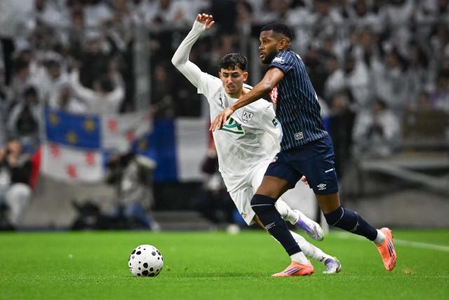 Amiens’ French forward #07 Ilyиs Hamache (L) fights for the ball with Le Havre’s French defender #07 Loic Nego during the French Cup round of 64 football match between Le Havre and Amiens at the Oceane Stadium in Le Havre, north western France, on December 21, 2025. (Photo by Lou BENOIST / AFP)