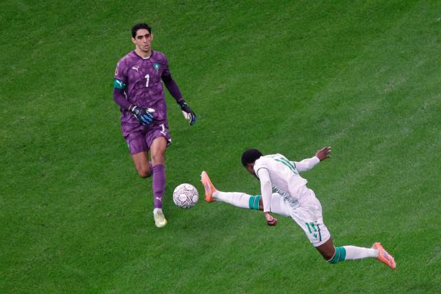 Morocco's goalkeeper #01 Yassine Bounou vies for the ball with Comoros's forward #11 Rafiki Said during the Africa Cup of Nations (CAN) group A  football match between Morocco and Comoros at Prince Moulay Abdellah Stadium in Rabat on December 21, 2025. (Photo by Abdel Majid BZIOUAT / AFP)