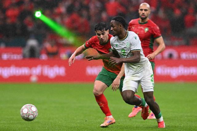 Morocco's forward #10 Brahim Diaz fights for the ball with Comoros's defender #02 Ismael Boura during the Africa Cup of Nations (CAN) group A  football match between Morocco and Comoros at Prince Moulay Abdellah Stadium in Rabat on December 21, 2025. (Photo by SEBASTIEN BOZON / AFP)