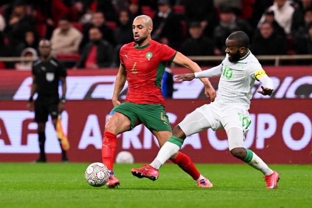Morocco's midfielder #04 Sofyan Amrabat fights for the ball with Comoros's midfielder #10 Youssouf M'Changama during the Africa Cup of Nations (CAN) group A  football match between Morocco and Comoros at Prince Moulay Abdellah Stadium in Rabat on December 21, 2025. (Photo by SEBASTIEN BOZON / AFP)