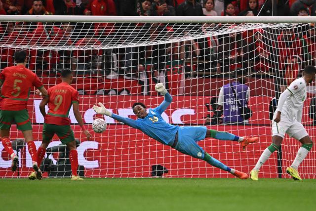 Comoros's goalkeeper #16 Yannick Pandor dives to save the ball during the Africa Cup of Nations (CAN) group A  football match between Morocco and Comoros at Prince Moulay Abdellah Stadium in Rabat on December 21, 2025. (Photo by SEBASTIEN BOZON / AFP)