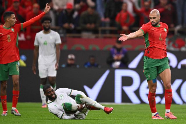 Comoros's forward #07 Faiz Selemani grimaces next to Morocco's defender #04 Sofyan Amrabat during the Africa Cup of Nations (CAN) group A  football match between Morocco and Comoros at Prince Moulay Abdellah Stadium in Rabat on December 21, 2025. (Photo by SEBASTIEN BOZON / AFP)