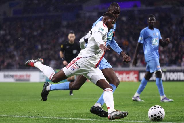 Lyon's English midfielder Ainsley Maitland-Niles (C-L) fights for the ball with FC Saint-Cyr Collonges' French defender Sekhouba Souare during the French Cup round of 64 football match between - Olympique Lyonnais (OL) and Saint-Cyr-Collonges at the Groupama Stadium in Lyon, south eastern France on December 21, 2025. (Photo by Alex MARTIN / AFP)