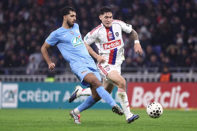 FC Saint-Cyr Collonges French defender Foudil Bakhtia (L) fights for the ball with Lyon's Uruguayan forward Martin Satriano (R) during the French Cup round of 64 football match between Olympique Lyonnais (OL) and Saint-Cyr-Collonges at the Groupama Stadium in Lyon, south eastern France on December 21, 2025. (Photo by Alex MARTIN / AFP)