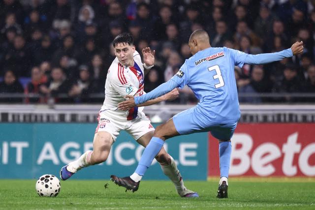 Lyon's Uruguayan forward Martin Satriano (L) vies with FC Saint-Cyr Collonges French defender Oualid Zemmouri (R) during the French Cup round of 64 football match between Olympique Lyonnais (OL) and Saint-Cyr-Collonges at the Groupama Stadium in Lyon, south eastern France on December 21, 2025. (Photo by Alex MARTIN / AFP)