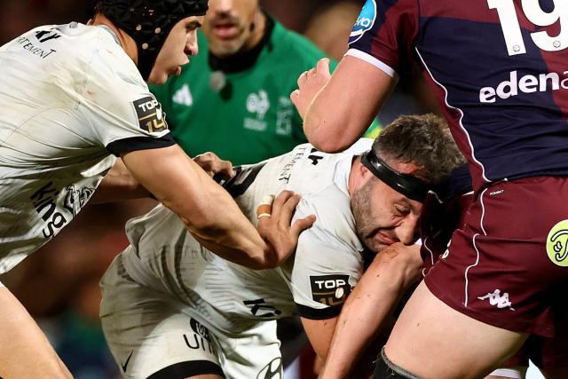 TOPSHOT - Toulon' French wing Jeremy Sinzelle (C) is tackled during the French Top14 rugby union match between Union Bordeaux-Begles (UBB) and Rugby Club Toulonnais (Toulon) at the Chaban-Delmas Stadium in Bordeaux, south-western France on December 21, 2025. (Photo by ROMAIN PERROCHEAU / AFP)