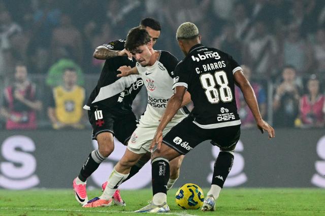 Corinthians' midfielder #27 Breno Bidon fights for the ball with Vasco da Gama's midfielders #11 Philippe Coutinho and  #88 Cauan Barros during the Brazil Cup final second leg football match between Vasco da Gama and Corinthians at the Maracana stadium in Rio de Janeiro, Brazil on December 21, 2025. (Photo by Pablo PORCIUNCULA / AFP)