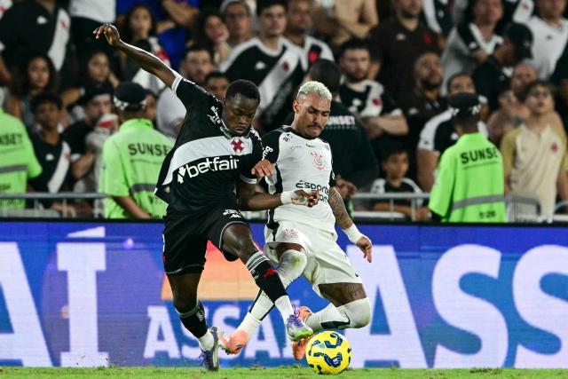 Vasco da Gama's Colombian forward #11 Andres Gomez and Corinthians' defender #02 Matheuzinho fight for the ball during the Brazil Cup final second leg football match between Vasco da Gama and Corinthians at the Maracana stadium in Rio de Janeiro, Brazil on December 21, 2025. (Photo by Pablo PORCIUNCULA / AFP)