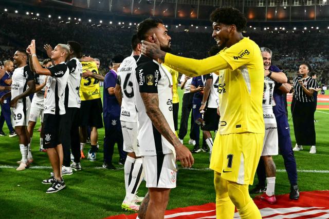 Corinthians' midfielder #14 Raniele and Corinthians' goalkeeper #01 Hugo Souza celebrate at the end of the Brazil Cup final second leg football match between Vasco da Gama and Corinthians at the Maracana stadium in Rio de Janeiro, Brazil on December 21, 2025. (Photo by Pablo PORCIUNCULA / AFP)