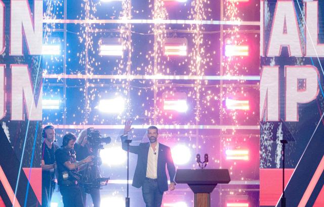 Donald Trump Jr. waves as he steps on stage during Turning Point's annual AmericaFest conference in Phoenix, Arizona on December 21, 2025. This year’s conference commemorates the late right-wing activist Charlie Kirk, who was fatally shot on a Utah college campus in September, sparking an outpouring of grief among conservatives and prompting President Donald Trump to threaten a crackdown on the "radical left." (Photo by Olivier Touron / AFP)