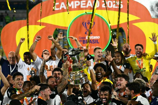 Corinthians' players celebrate with the trophy of the Brazil Cup after the final second leg football match between Vasco da Gama and Corinthians at the Maracana stadium in Rio de Janeiro, Brazil on December 21, 2025. (Photo by Pablo PORCIUNCULA / AFP)