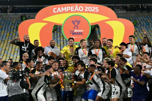 Corinthians' players celebrate with the trophy of the Brazil Cup after the final second leg football match between Vasco da Gama and Corinthians at the Maracana stadium in Rio de Janeiro, Brazil on December 21, 2025. (Photo by Pablo PORCIUNCULA / AFP)