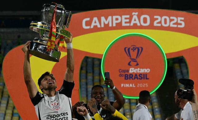 Corinthians' Paraguayan forward #11 Angel Romero celebrates with the trophy after the Brazil Cup final second leg football match between Vasco da Gama and Corinthians at the Maracana stadium in Rio de Janeiro, Brazil on December 21, 2025. (Photo by Pablo PORCIUNCULA / AFP)