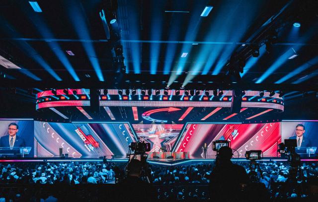 Attendees listen to US Speaker of the House Mike Johnson speak on stage during Turning Point's annual AmericaFest conference in Phoenix, Arizona on December 21, 2025. This year’s conference commemorates the late right-wing activist Charlie Kirk, who was fatally shot on a Utah college campus in September, sparking an outpouring of grief among conservatives and prompting President Donald Trump to threaten a crackdown on the "radical left." (Photo by Olivier Touron / AFP)