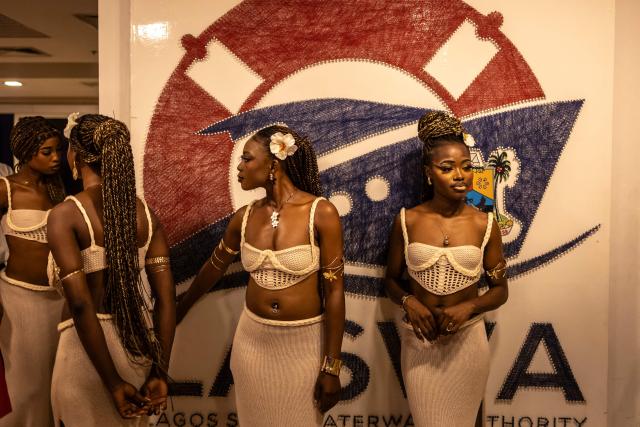 Hostesses stand at the entrance of the Lulu beach club during its opening during “Detty December” in Lagos on November 21, 2025. “Detty December” refers to the lively Lagos tradition where December is packed with nonstop parties, concerts, nightlife, and cultural events, fuelled by returning diaspora Nigerians and heightened local celebration. The city becomes especially vibrant and crowded as entertainment and tourism peak. The spelling “detty” comes from Nigerian Pidgin English, where it is a playful version of “dirty” that implies excess, intensity, and carefree fun. (Photo by OLYMPIA DE MAISMONT / AFP)