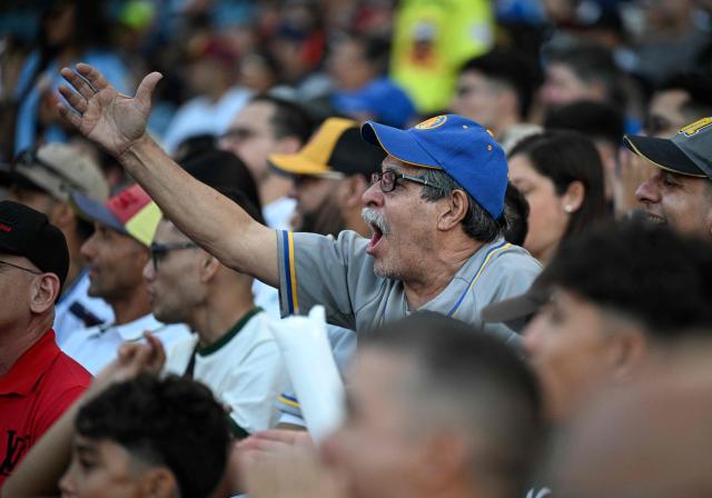 A fan of Navegantes del Magallanes cheers for his team during the baseball game between Navegantes del Magallanes and Leones del Caracas at Simon Bolivar Monumental Stadium in Caracas on December 21, 2025. (Photo by Federico PARRA / AFP)