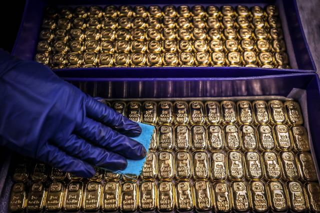 (FILES) A worker polishes gold bullion bars at the ABC Refinery in Sydney on August 5, 2020. Gold prices shot to a record high on December 22, 2025 as investors grow increasingly optimistic the US Federal Reserve will continue to cut interest rates through next year. (Photo by DAVID GRAY / AFP)