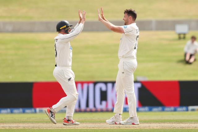 New Zealand’s Jacob Duffy and Glenn Phillips celebrate victory after day five of the 3rd international Test cricket match between New Zealand and West Indies at Bay Oval in Mount Maunganui, Tauranga, New Zealand on December 22, 2025. (Photo by Michael Bradley / AFP)