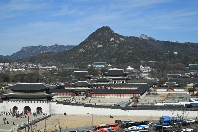 The Blue House (C), known as Cheong Wa Dae in Korean, is seen over Gyeongbokgung Palace in Seoul on December 22, 2025. South Korea's president and his team have started moving back into Seoul's historic Blue House and the process will be wrapped up by Christmas, an official said on December 9. (Photo by Jung Yeon-je / AFP)