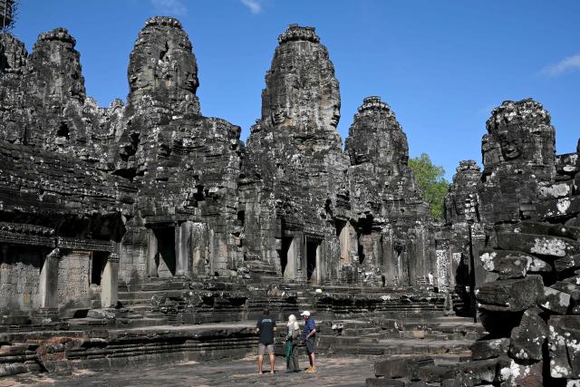 TOPSHOT - This photo taken on December 18, 2025 shows tourists visiting the Bayon temple in Siem Reap province.  (Photo by TANG CHHIN Sothy / AFP)