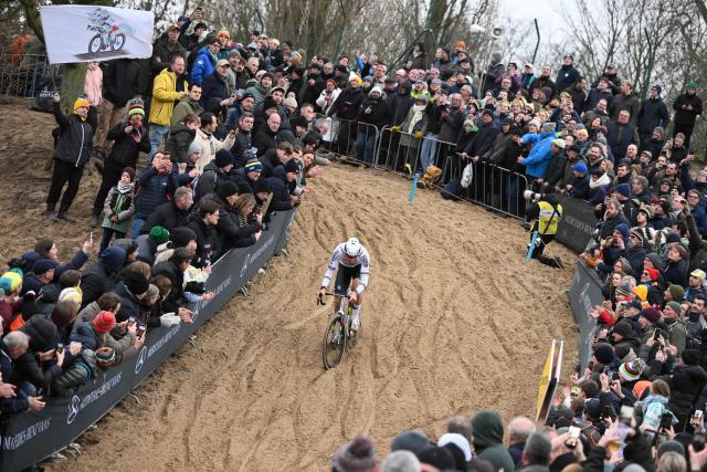 Fans cheer as Alpecin-Deceuninck's Dutch rider Mathieu van der Poel competes in the men's elite race of the cyclo-cross World Cup, stage 6 out of 12 of the UCI World Cup competition, in Koksijde on December 21, 2025. (Photo by Nicolas TUCAT / AFP)
