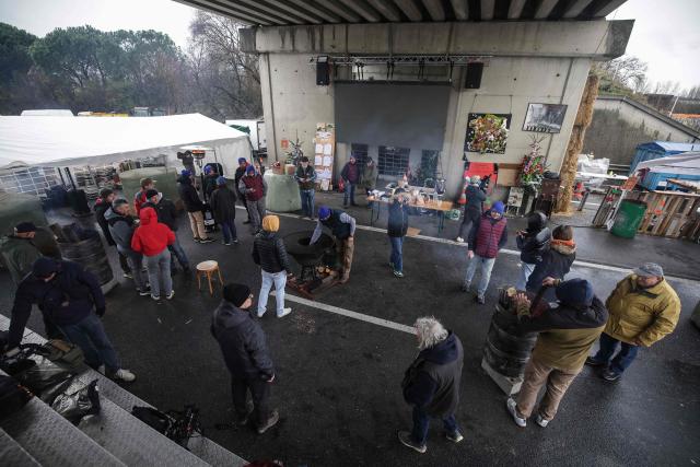 Farmers gather on the A64 motorway during a farmers blockade to protest against the government's mandatory culling protocol for cattle herds affected by lumpy skin disease (dermatose nodulaire contagieuse), in Carbonne, south-western France on December 22, 2025. (Photo by Valentine CHAPUIS / AFP)