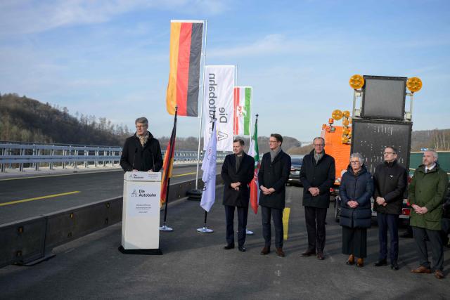 German Transport Minister Patrick Schnieder speaks at the opening ceremony attended by including (L-R) Michael Guentner, CEO of the Motorway company, North-Rhine Westphalia's State Premier Hendrik Wuest and German Chancellor Friedrich Merz for the reconstructed Rahmede bridge on the A45 motorway, near Luedenscheid, western Germany on December 22, 2025. Following a routine inspection of the Rahmede viaduct in December 2021, inspectors discovered deformations in the steel wall that could affect the bridge's load-bearing capacity, leading to its reconstruction. (Photo by Sascha Schuermann / AFP)