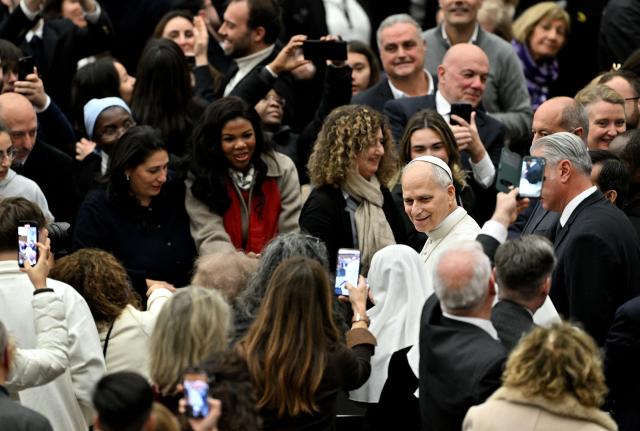 Pope Leo XIV smiles at the end of an audience in the Paul VI Hall in the Vatican on December 22, 2025, for Christmas greetings to the employees of the Holy See, the Governorate of Vatican City State and the Vicariate of Rome. (Photo by TIZIANA FABI / AFP)