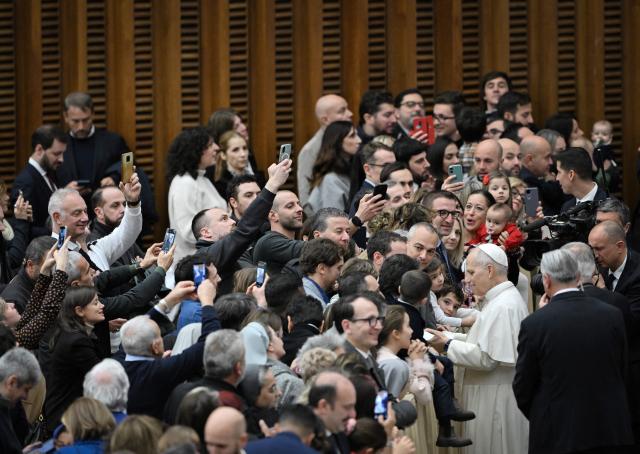 Pope Leo XIV greets the crowd at the end of an audience in the Paul VI Hall in the Vatican on December 22, 2025, for Christmas greetings to the employees of the Holy See, the Governorate of Vatican City State and the Vicariate of Rome. (Photo by TIZIANA FABI / AFP)