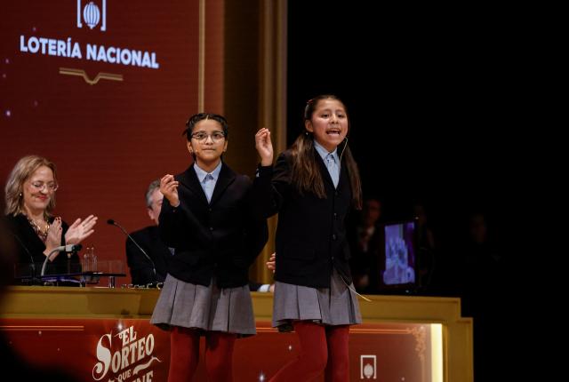 A schoolgirl calls out the winning number of the biggest prize of Spain's Christmas lottery "El Gordo" (the Fat One) at the Royal Theatre in Madrid on December 22, 2025. (Photo by OSCAR DEL POZO / AFP)
