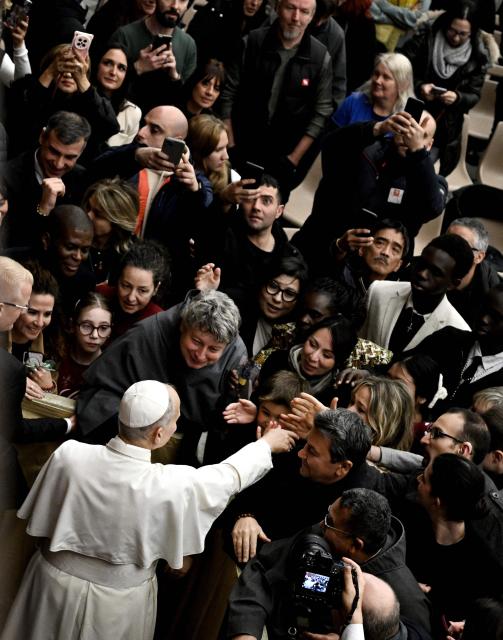 Pope Leo XIV waves at the end of an audience in the Paul VI Hall in the Vatican on December 22, 2025, for Christmas greetings to the employees of the Holy See, the Governorate of Vatican City State and the Vicariate of Rome. (Photo by TIZIANA FABI / AFP)