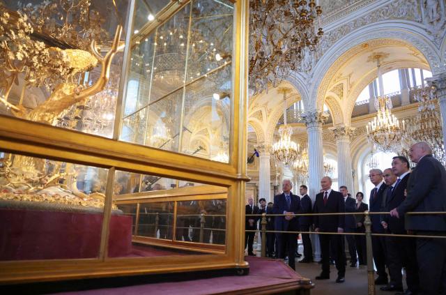 In this pool photograph distributed by the Russian state agency Sputnik, participants of an informal summit of the Commonwealth of Independent States (CIS) leaders, including Russia's President Vladimir Putin, tour the State Hermitage Museum in Saint Petersburg on December 22, 2025. (Photo by Alexander KAZAKOV / POOL / AFP)