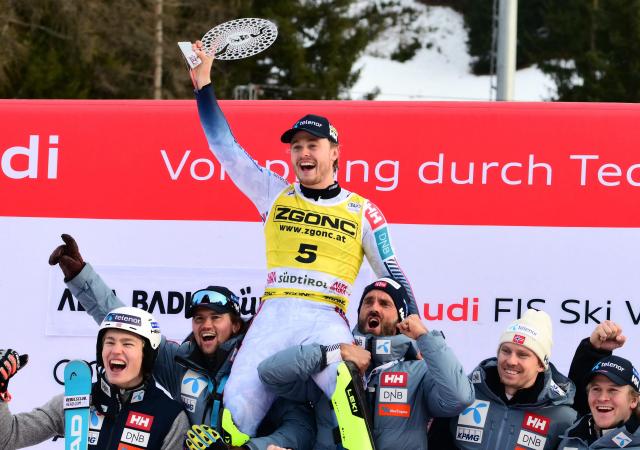 First placed Norway's Atle Lie Mcgrath (C) celebrates with teammates on the podium of the Men's Slalom event, as part of the FIS Alpine Ski World Cup 2025-2026, in Alta Badia, northern Italy, on December 22, 2025. (Photo by Stefano RELLANDINI / AFP)